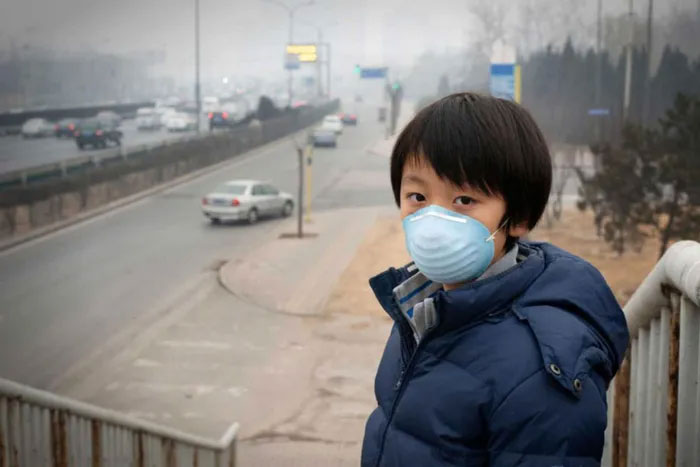 Một cậu bé đeo khẩu trang để giảm tác hại ô nhiễm không khí do ô tô gây ra ở Bắc Kinh.