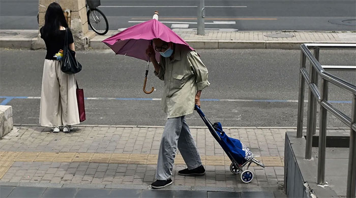 Một người đàn ông lớn tuổi chật vật trước cái nóng ở Bắc Kinh vào tháng 7/2023