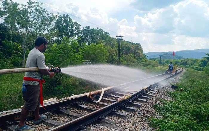 Công nhân đường sắt phun nước trên đường ray bị cong vênh do nắng nóng