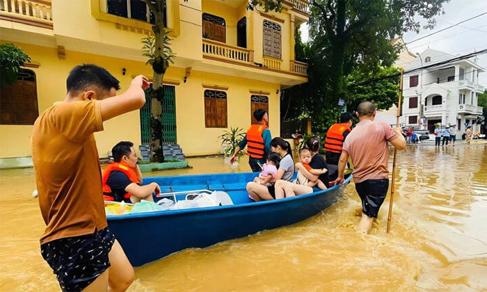 Lực lượng chức năng di dời các hộ dân bị ngập sâu đến nơi an toàn.