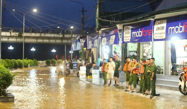 Lực lượng chức năng làm việc tại những điểm ngập lụt giúp dân phòng tránh lũ lụt.