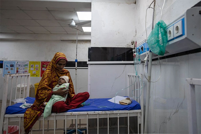 Sumaira, 25 tuổi, ôm con trong Bệnh viện Dịch vụ (Services Hospital) ở Lahore, Pakistan.